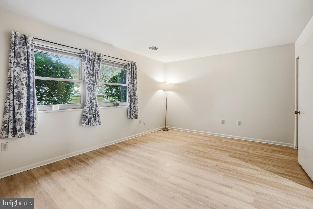 3362 Gleneagles Drive, Unit 711D Silver Spring, MD 20906 - Photo 7 of 26 a view of an empty room with wooden floor and a window