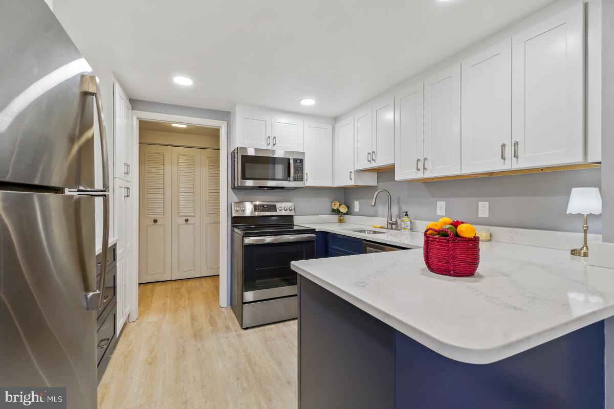 3362 Gleneagles Drive, Unit 711D Silver Spring, MD 20906 - Photo 10 of 26 a kitchen with a refrigerator a stove a sink and white cabinets