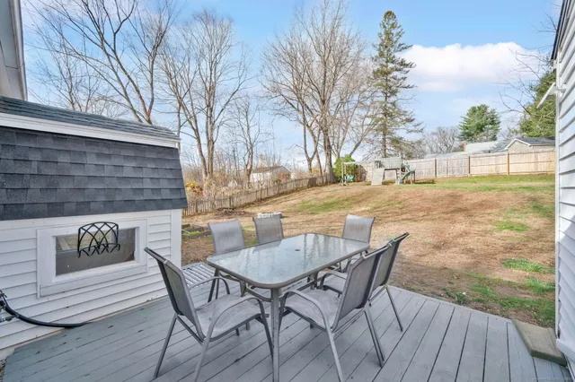 a view of a backyard with table and chairs with wooden floor and fence