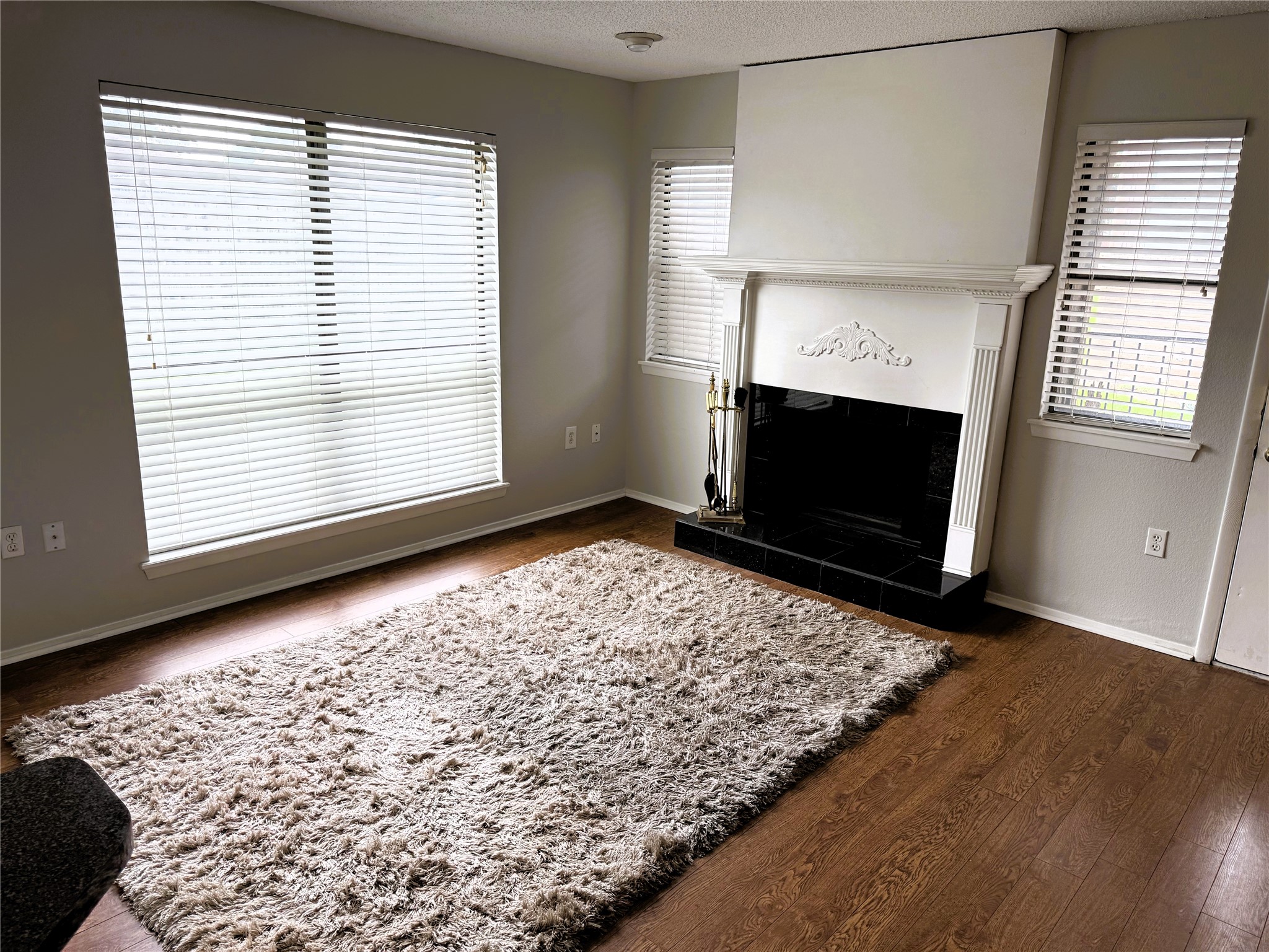 62 Evanston Street, Unit 2/5 Houston, TX 77015 - Photo 2 of 24 an empty room with wooden floor a fireplace and windows