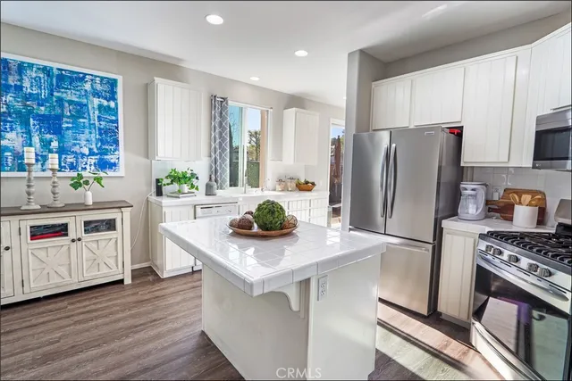 a kitchen with stainless steel appliances a stove refrigerator sink and microwave