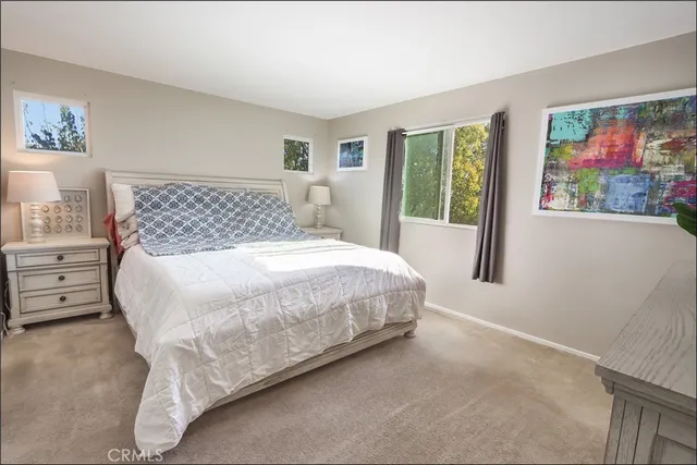a large bed sitting in a bedroom next to a window
