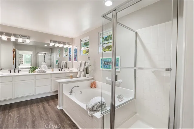 a large bathroom with a tub sink shower and mirror