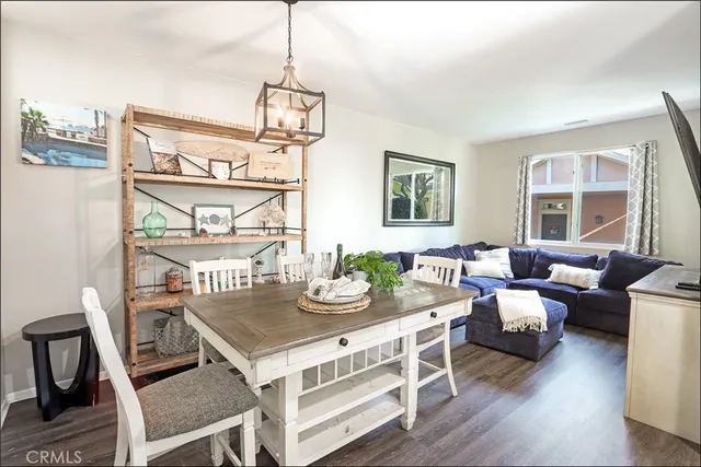 a view of a dining room with furniture a potted plant and wooden floor