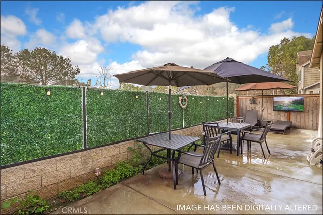 a view of patio with chairs and table under an umbrella