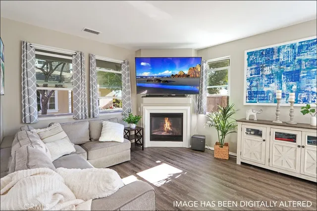 a living room with furniture a flat screen tv and a fireplace