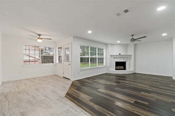 a view of an empty room with a window and fireplace