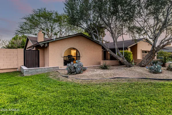 a view of a house with backyard and a tree