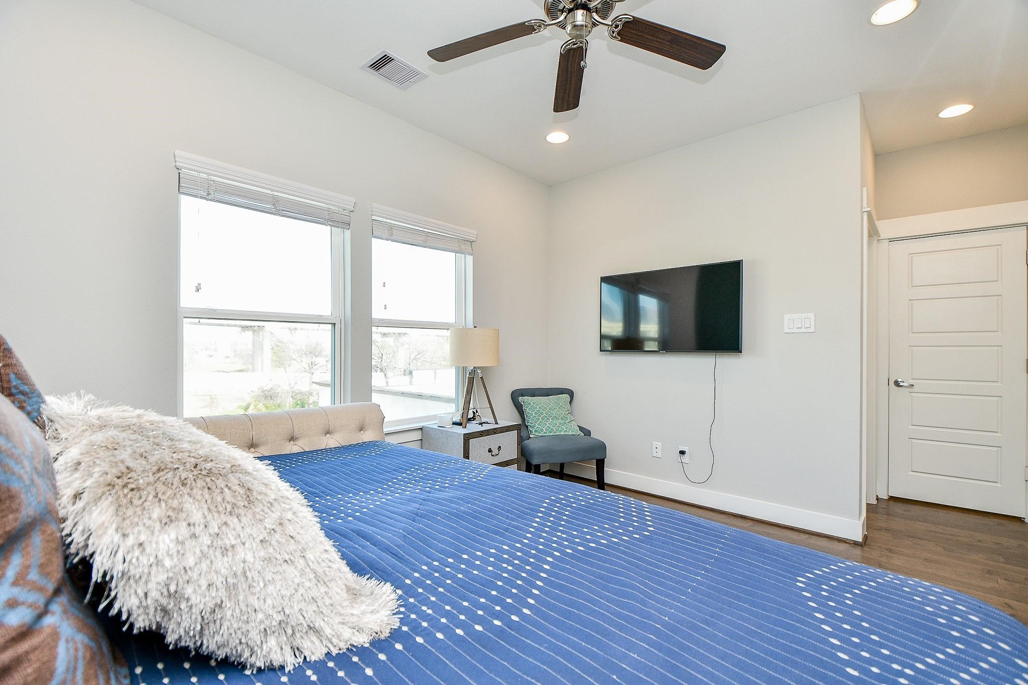 2010 St Charles Street Houston, TX 77003 - Photo 23 of 44 a spacious bedroom with a bed and a flat screen tv