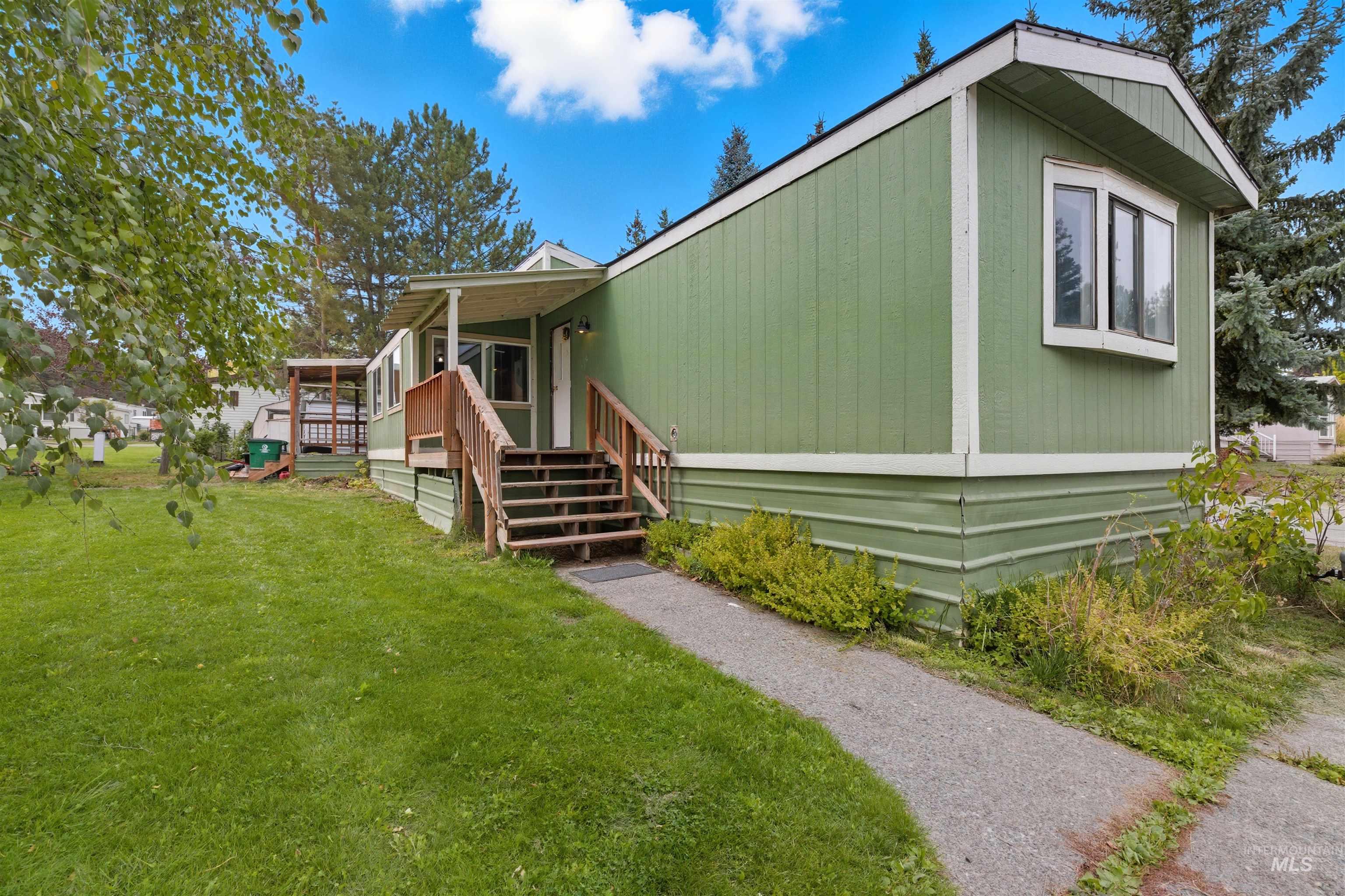 View of home's exterior featuring a lawn and stairs