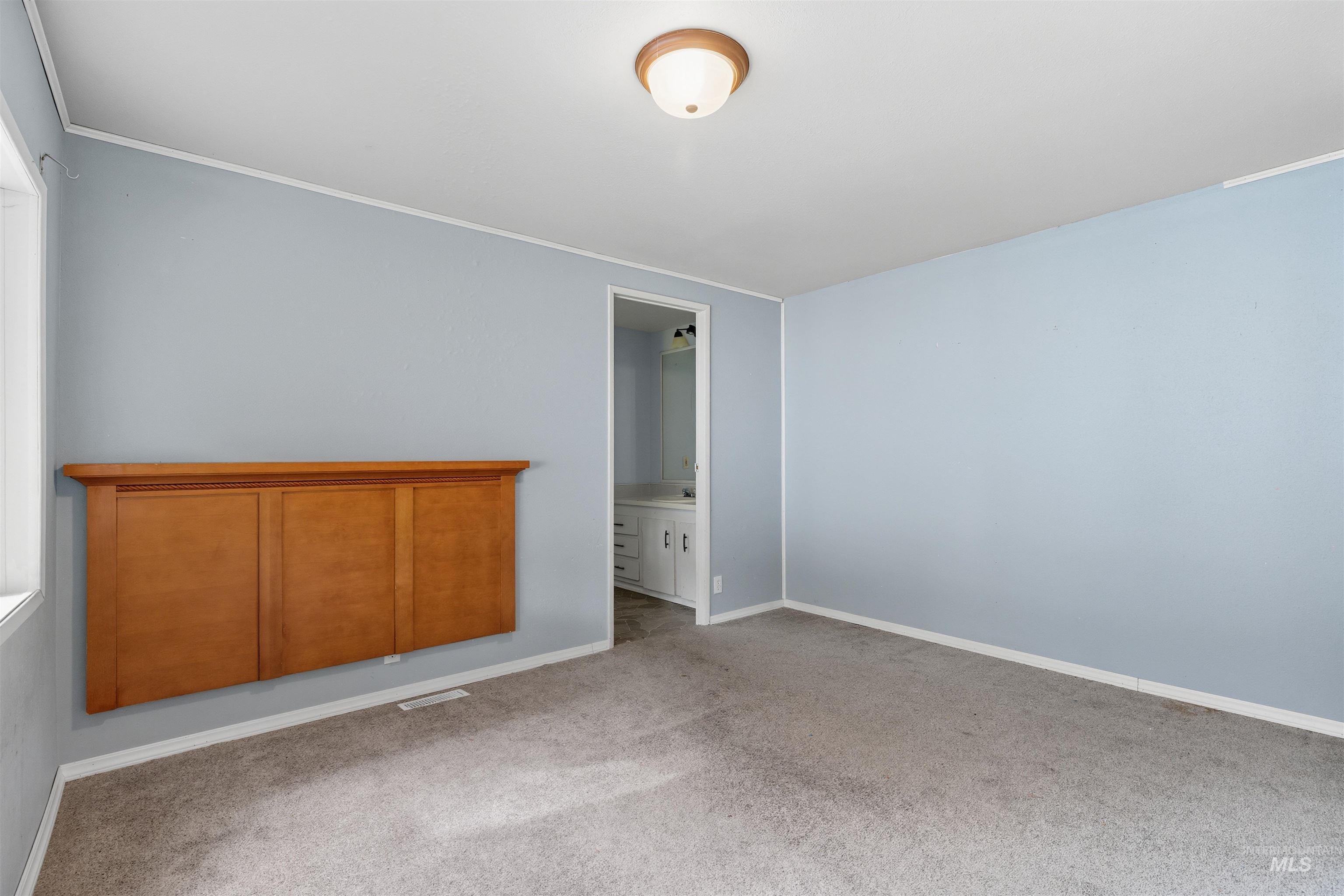 609 North Almon Street, Unit 2003 Moscow, ID 83843 - Photo 12 of 18 Unfurnished bedroom featuring carpet, ensuite bath, and ornamental molding
