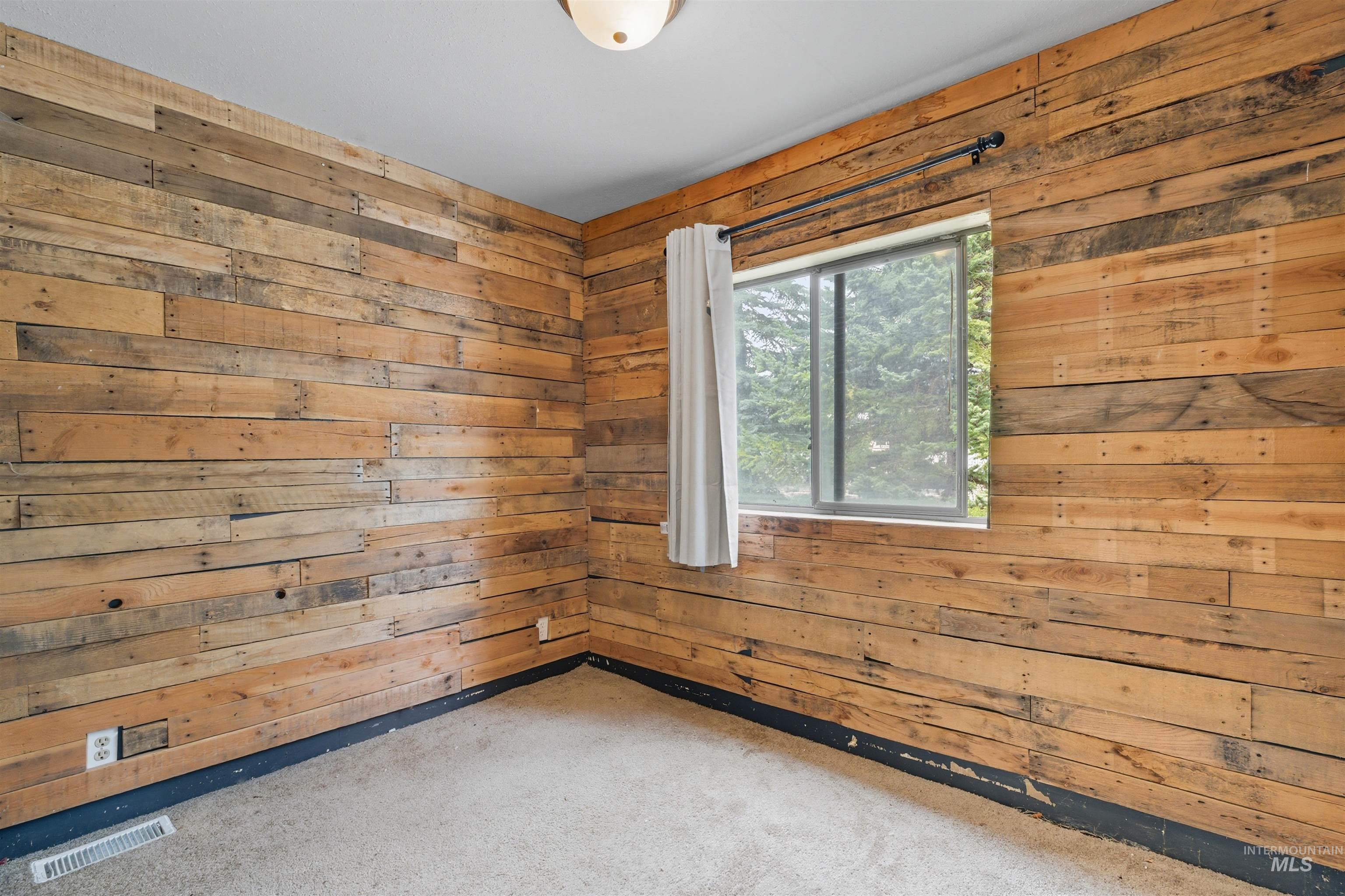 609 North Almon Street, Unit 2003 Moscow, ID 83843 - Photo 4 of 18 Carpeted empty room with wood walls
