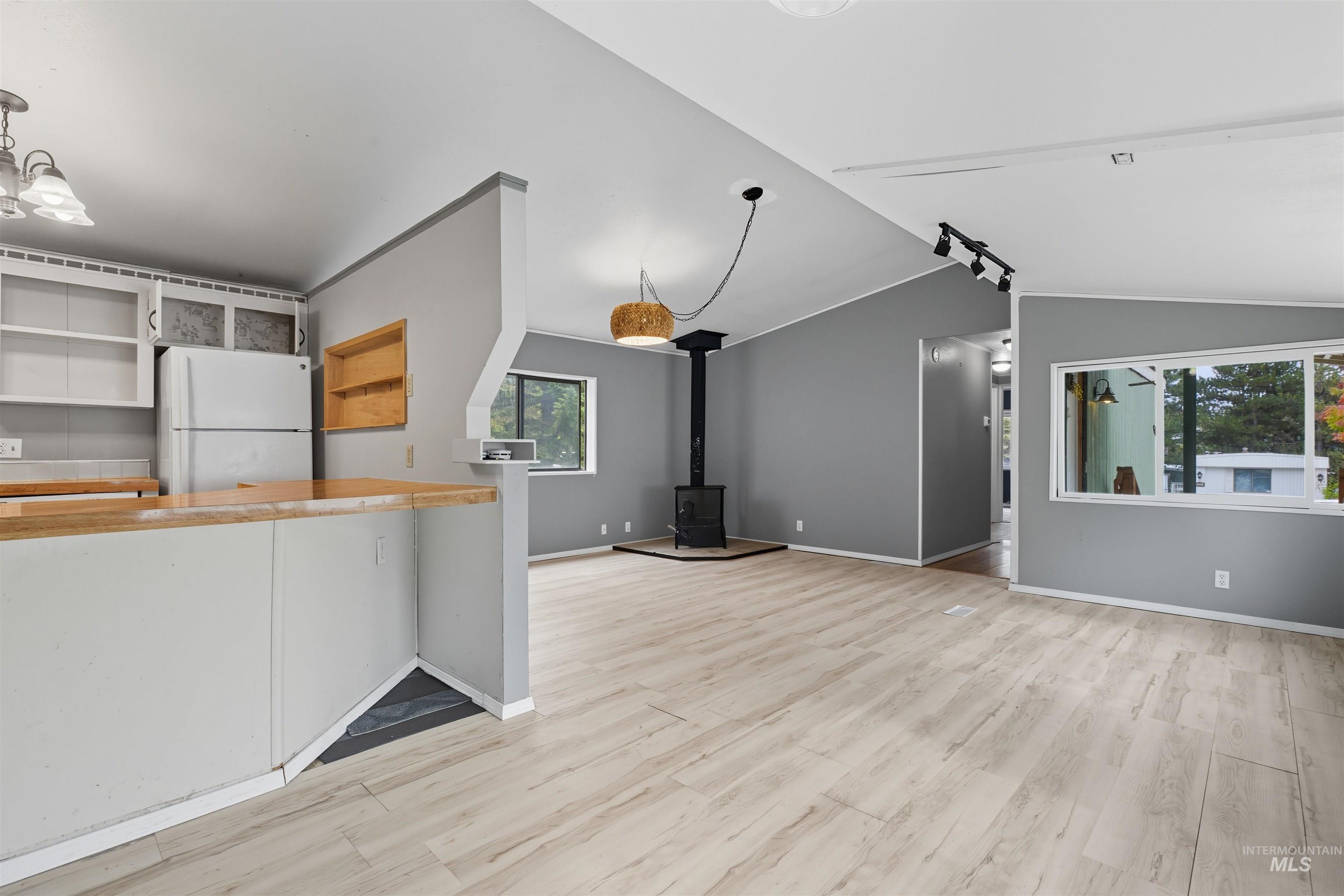 609 North Almon Street, Unit 2003 Moscow, ID 83843 - Photo 9 of 18 Unfurnished living room with a wood stove, light wood finished floors, and lofted ceiling