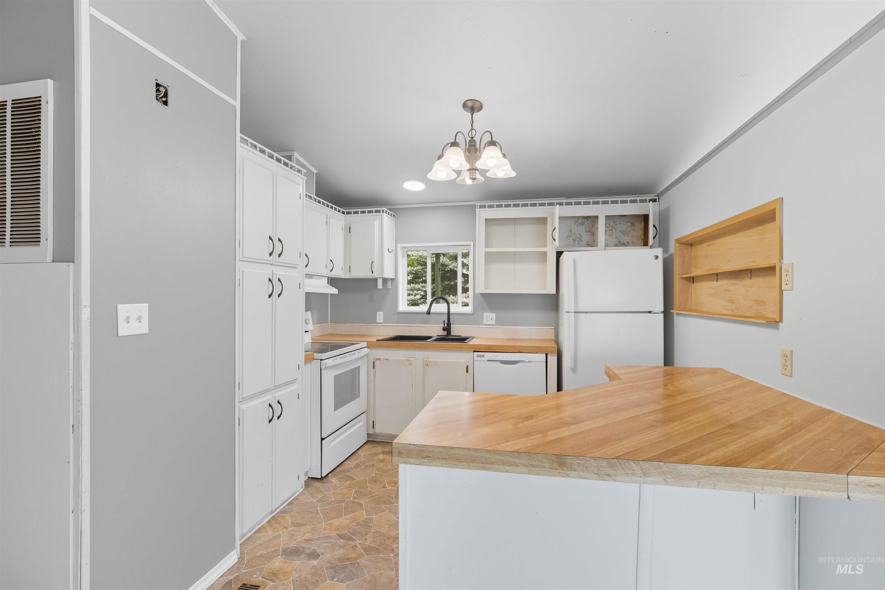 609 North Almon Street, Unit 2003 Moscow, ID 83843 - Photo 10 of 18 Kitchen with open shelves, white appliances, light countertops, stone finish flooring, and white cabinets