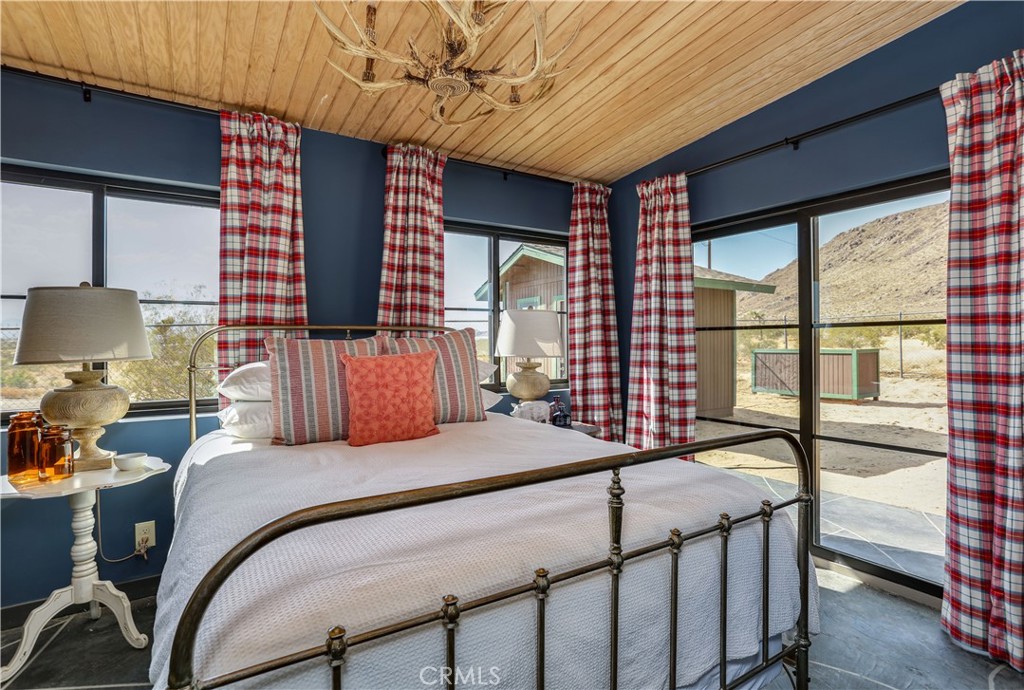 5969 Lorraine Road Yucca Valley, CA 92285 - Photo 15 of 45 a bedroom with a bed a dresser next to a window