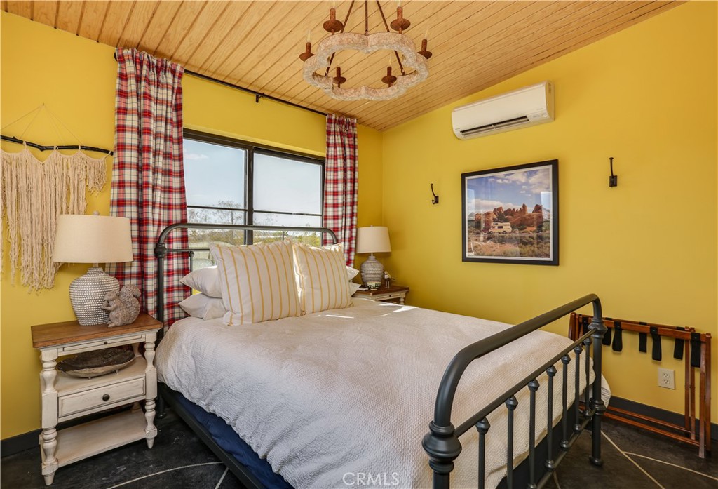 5969 Lorraine Road Yucca Valley, CA 92285 - Photo 23 of 45 a bedroom with a bed and wooden floor