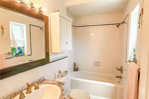 a bathroom with a bathtub a shower a sink and a mirror