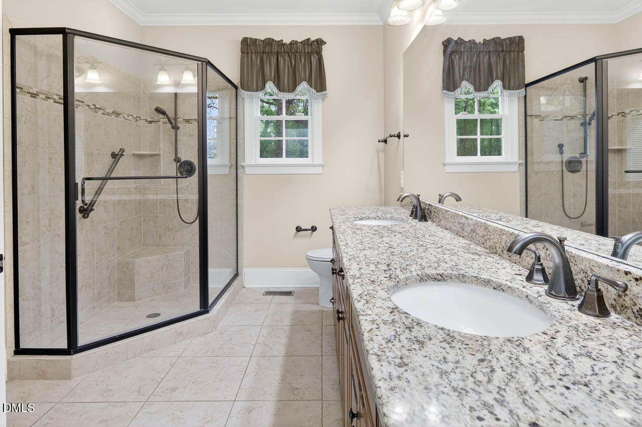 2209 Lodestar Drive Raleigh, NC 27615 - Photo 16 of 50 a bathroom with a granite countertop shower a mirror and a sink