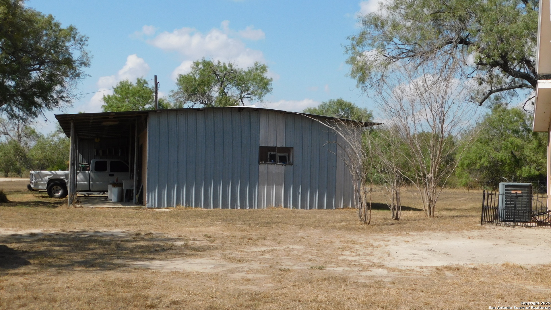 3 Gansky Lane Pleasanton, TX 78064 - Photo 27 of 45 a backyard of a house with table and chairs under an umbrella