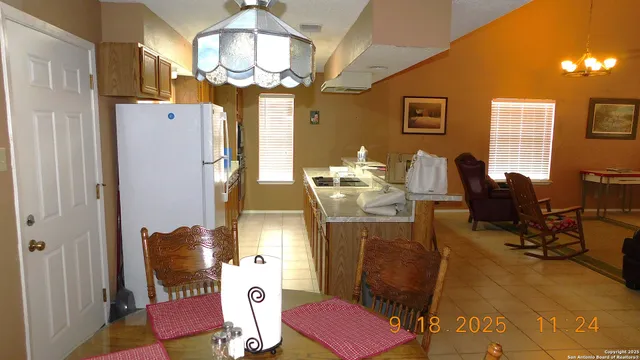 a dining room with furniture and large windows