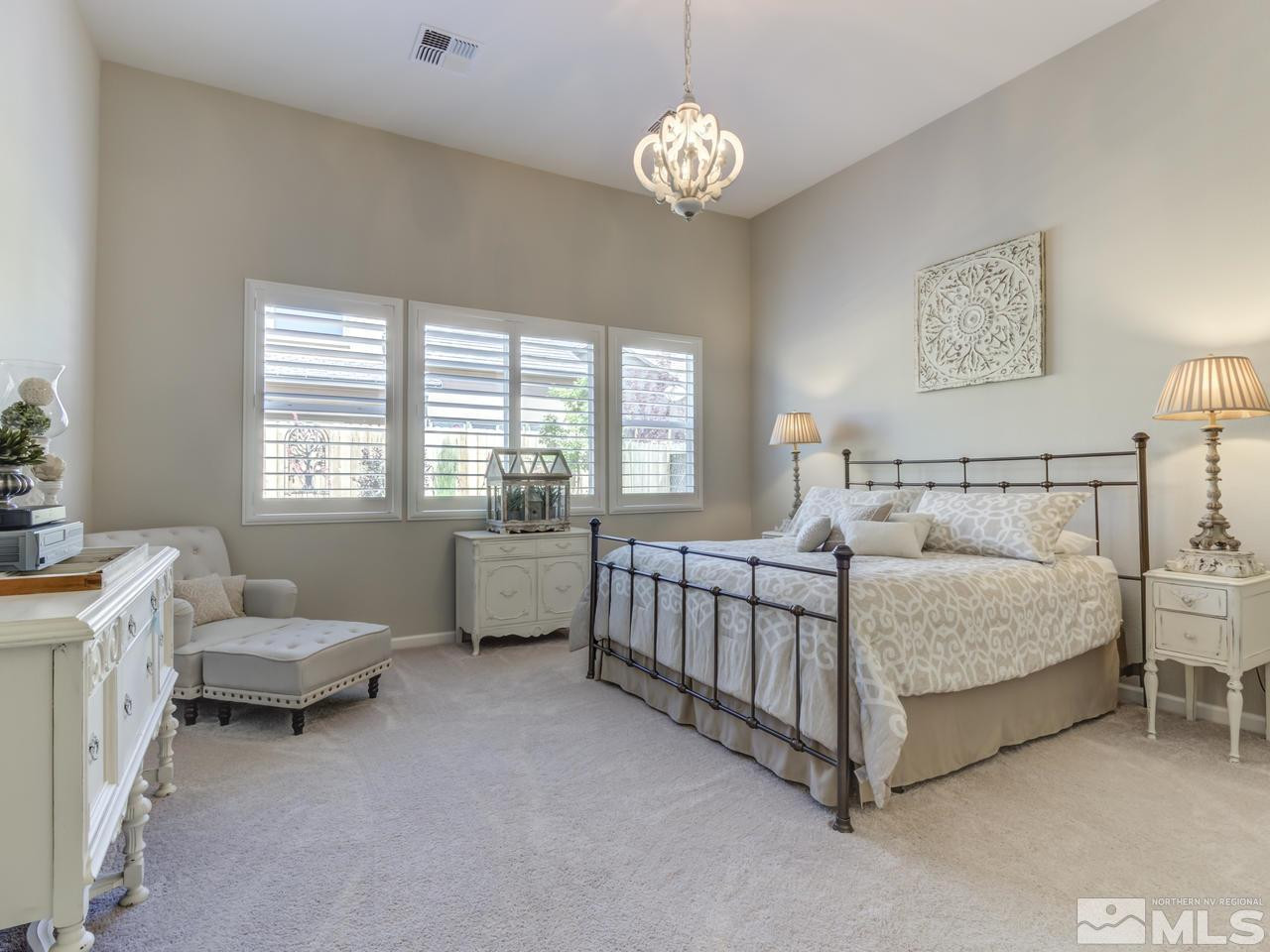 9465 Baldacci Road Reno, NV 89521 - Photo 12 of 25 a spacious bedroom with a bed and a chandelier