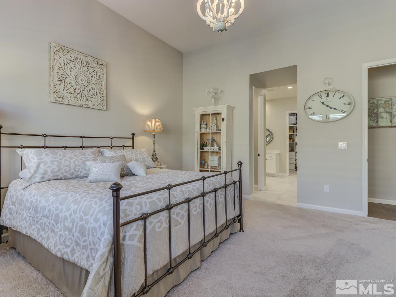 9465 Baldacci Road Reno, NV 89521 - Photo 13 of 25 a bedroom with a large bed and a chandelier