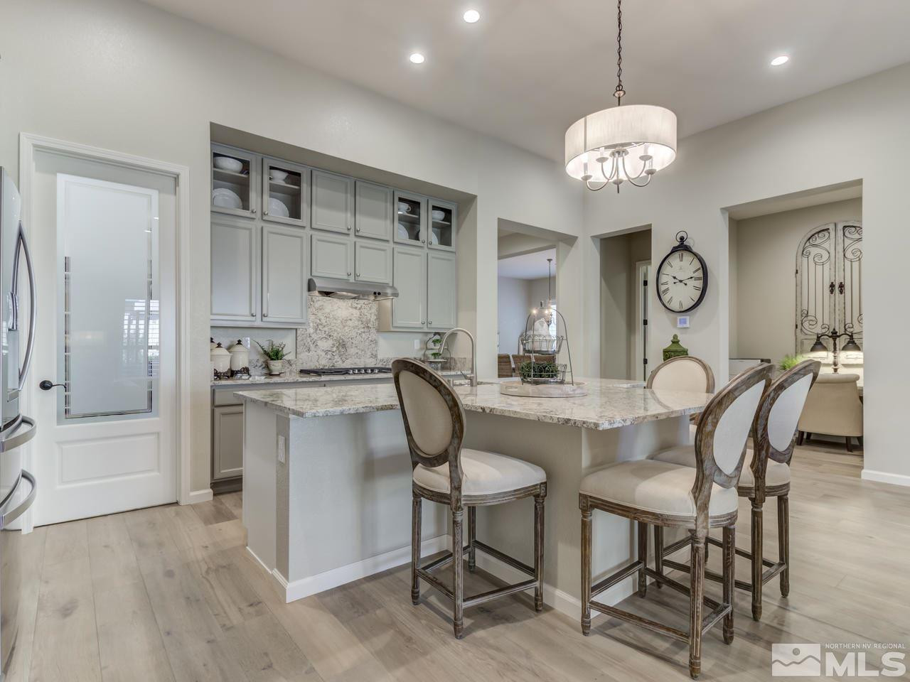 9465 Baldacci Road Reno, NV 89521 - Photo 8 of 25 a kitchen with stainless steel appliances granite countertop a table chairs and a chandelier