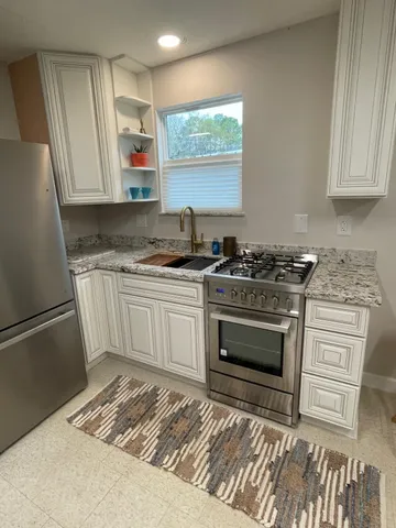 a kitchen with granite countertop a sink stainless steel appliances and cabinets