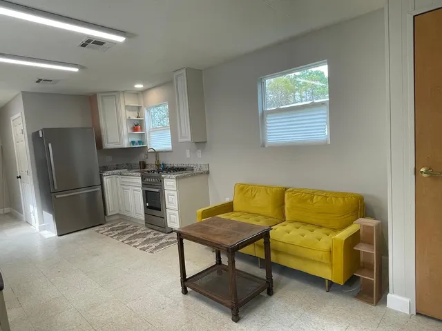 a kitchen with stainless steel appliances kitchen island granite countertop a refrigerator and a stove top oven