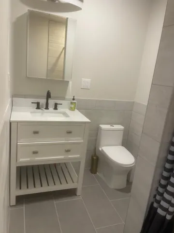 a bathroom with a toilet a sink and mirror