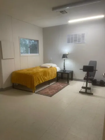 a bedroom with a bed chair and wall painting