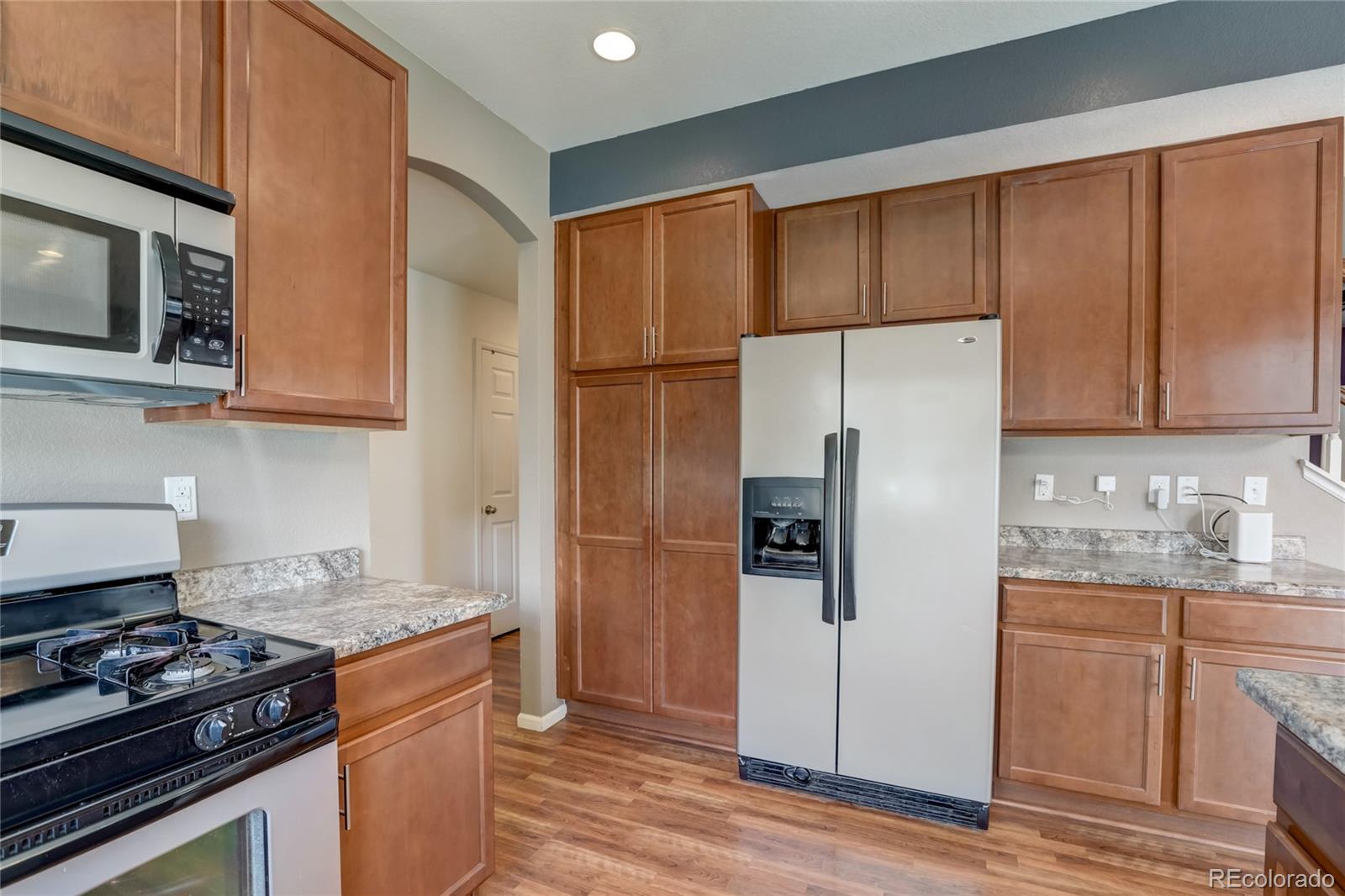 5545 Liverpool Street Denver, CO 80249 - Photo 13 of 40 a kitchen with stainless steel appliances granite countertop a refrigerator stove and microwave