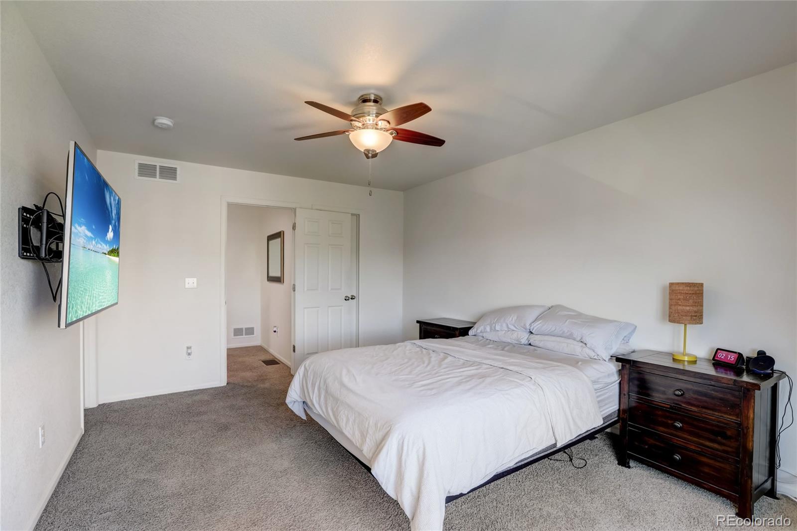 5545 Liverpool Street Denver, CO 80249 - Photo 16 of 40 a bedroom with a bed and a chandelier