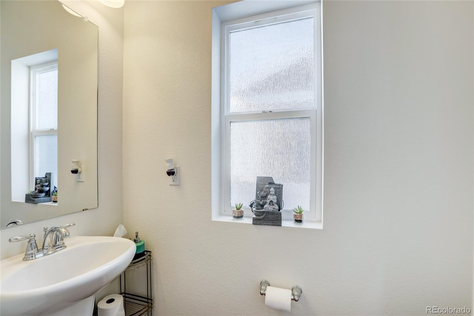 5545 Liverpool Street Denver, CO 80249 - Photo 29 of 40 a bathroom with a sink and a mirror
