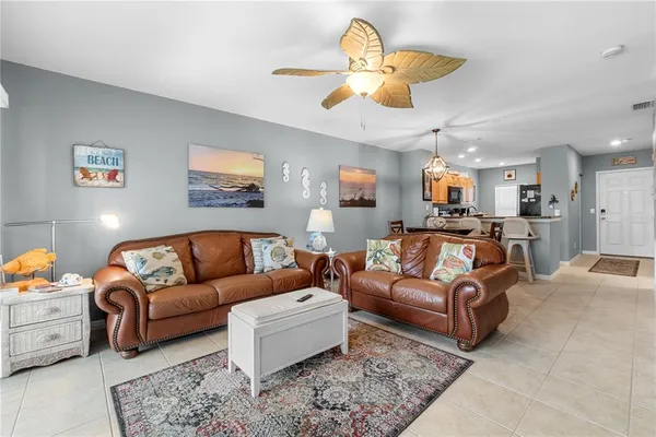 a living room with furniture kitchen view and a chandelier