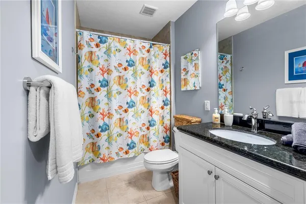 a bathroom with a granite countertop toilet sink and mirror