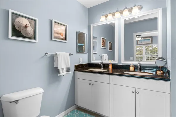 a bathroom with double sink and a toilet