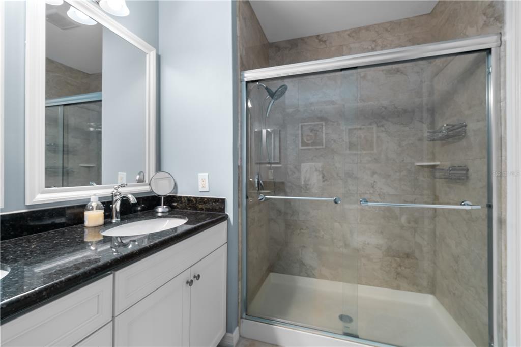 8405 Placida Road, Unit 206 Placida, FL 33946 - Photo 30 of 44 a bathroom with a granite countertop bathtub shower sink vanity and mirror