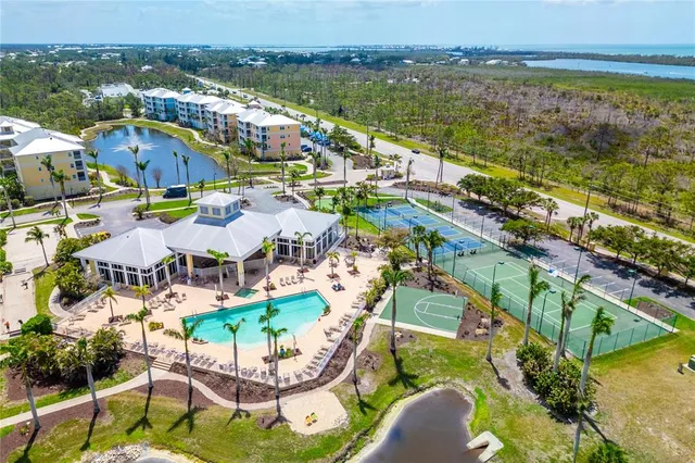 an aerial view of residential houses with outdoor space and ocean view