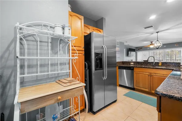 a kitchen with stainless steel appliances granite countertop a refrigerator a sink and a stove