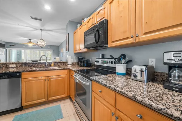 a kitchen with stainless steel appliances granite countertop a sink a stove and cabinets