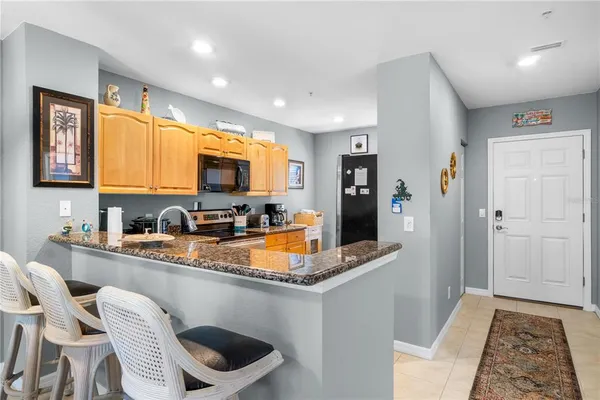 a kitchen with stainless steel appliances granite countertop a refrigerator and a stove top oven