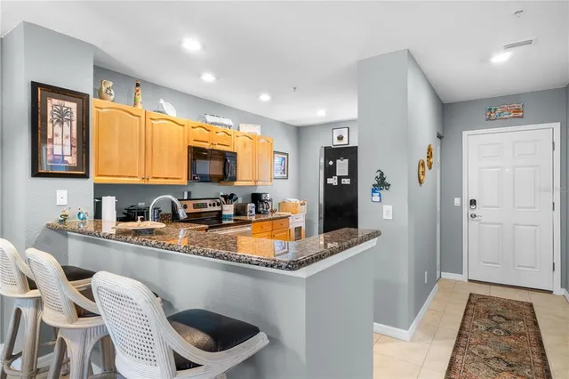 a kitchen with stainless steel appliances granite countertop a refrigerator and a stove top oven
