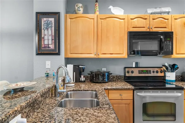 a kitchen with stainless steel appliances granite countertop a stove a sink and a microwave