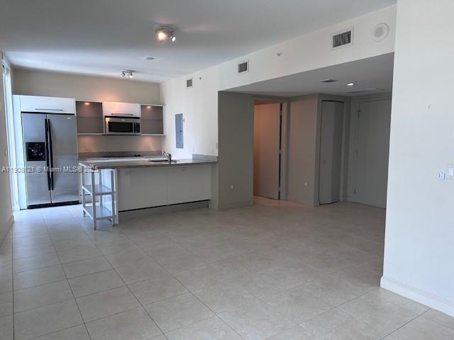 185 Southwest 7th Street, Unit 2300 Miami, FL 33130 - Photo 3 of 9 a living room with stainless steel appliances kitchen island furniture and a television