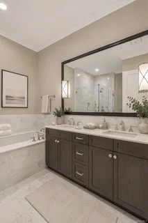 a spacious bathroom with a granite countertop double vanity sink and a bathtub