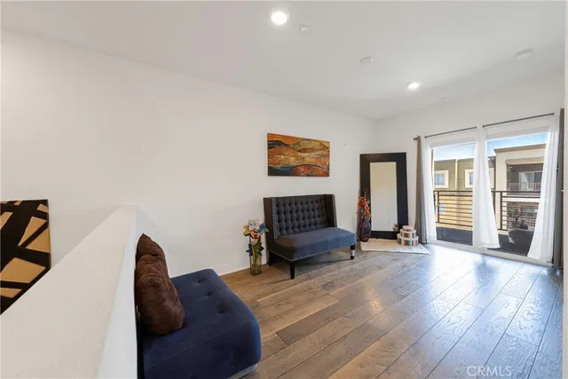 a view of a livingroom with wooden floor and a ceiling fan