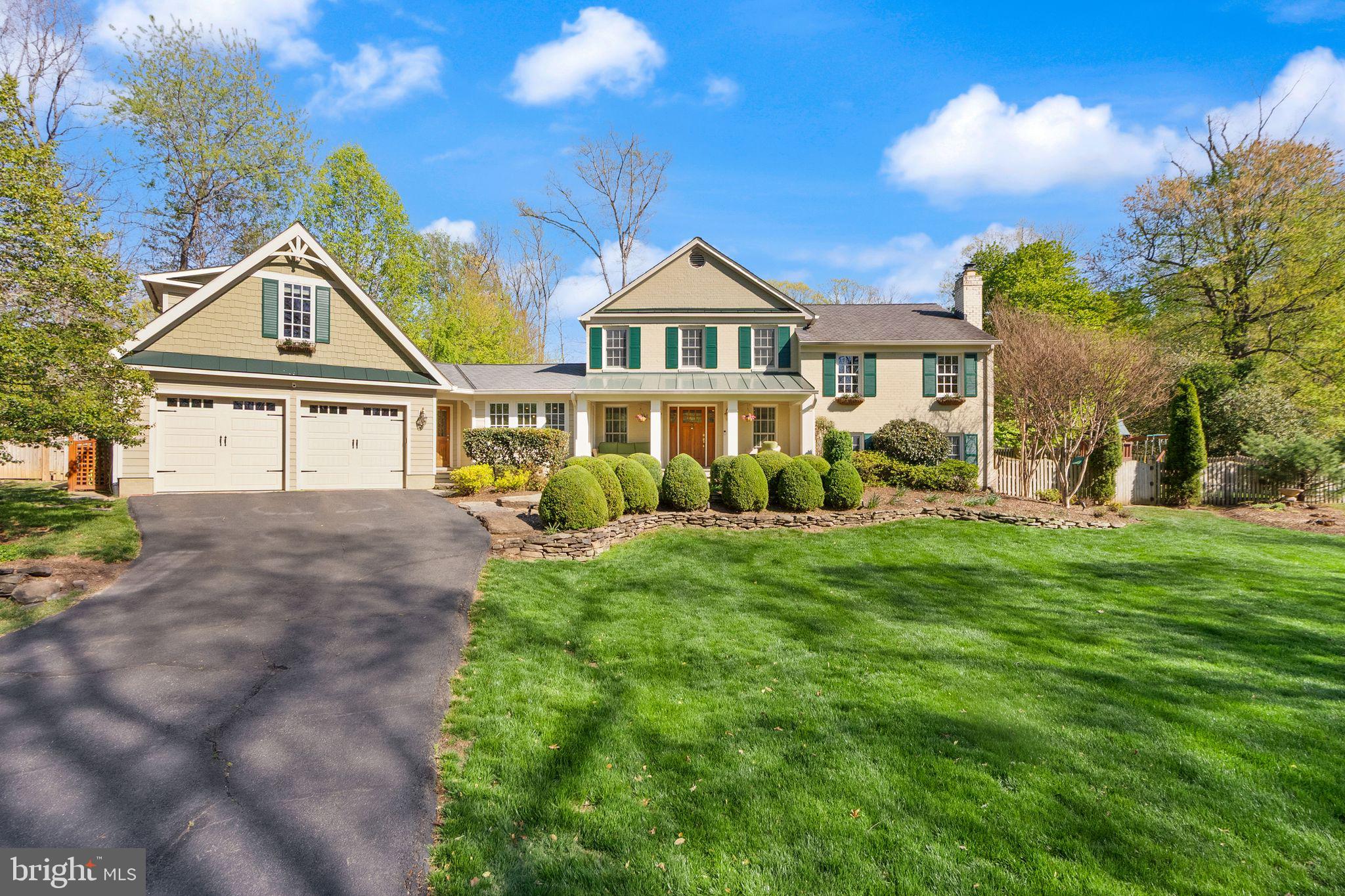 a front view of a house with a garden and yard