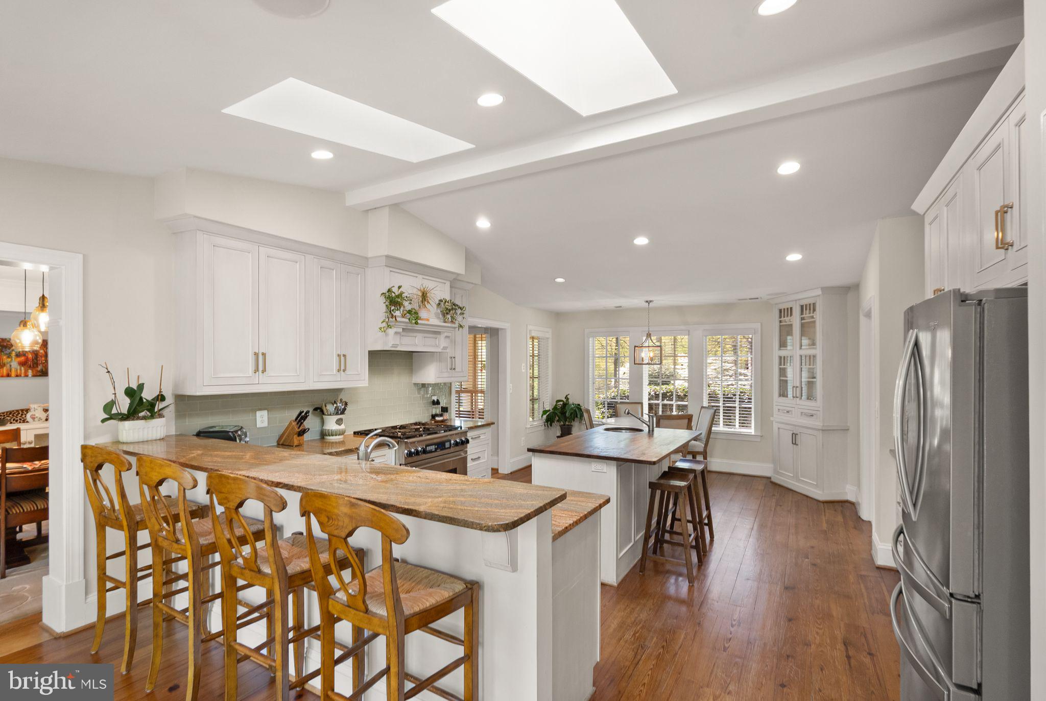 11809 Wayland Street Oakton, VA 22124 - Photo 26 of 97 a kitchen with stainless steel appliances granite countertop a refrigerator a sink a stove a dining table and chairs with wooden floor