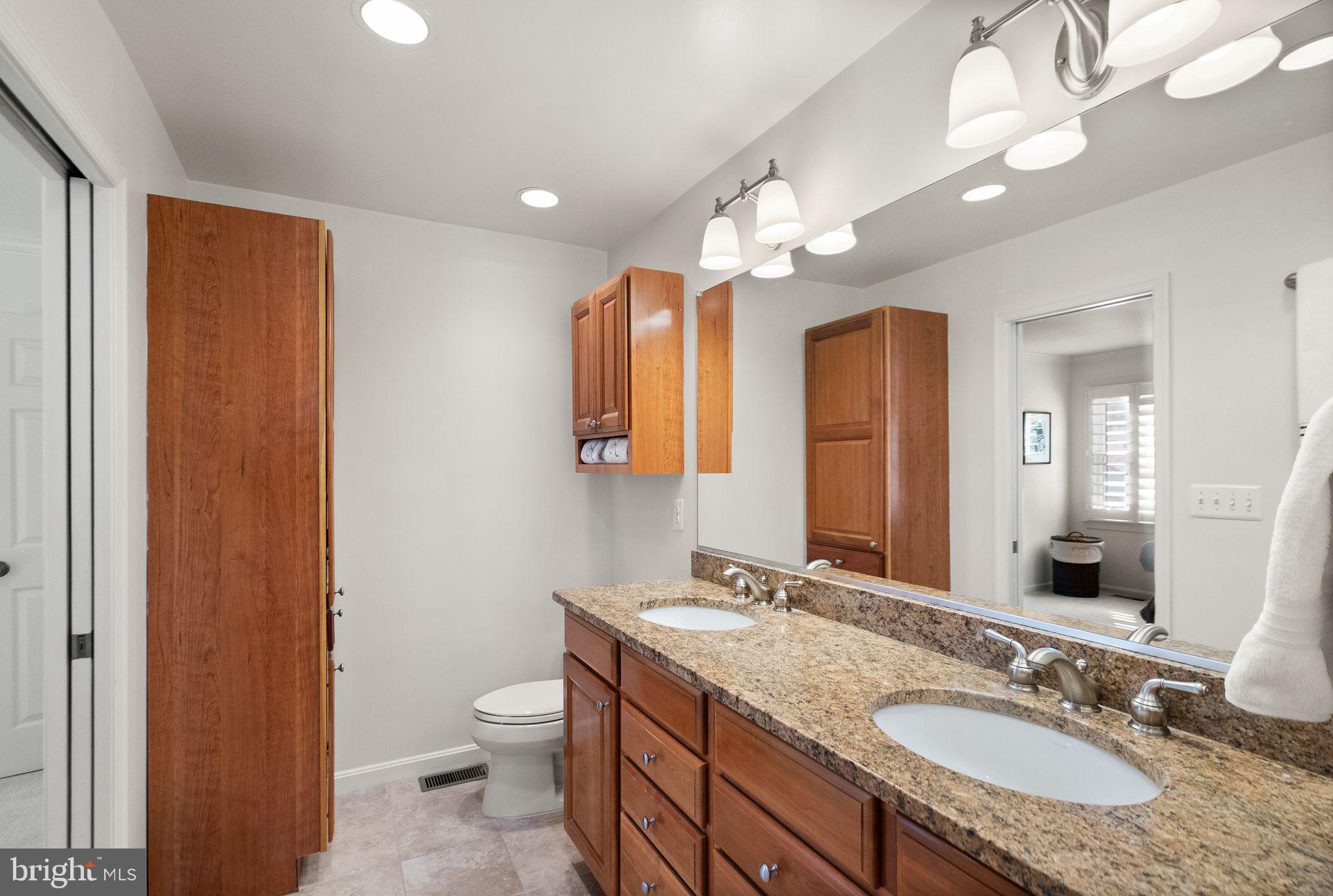 11809 Wayland Street Oakton, VA 22124 - Photo 37 of 97 a bathroom with a granite countertop double vanity sink a mirror and a toilet
